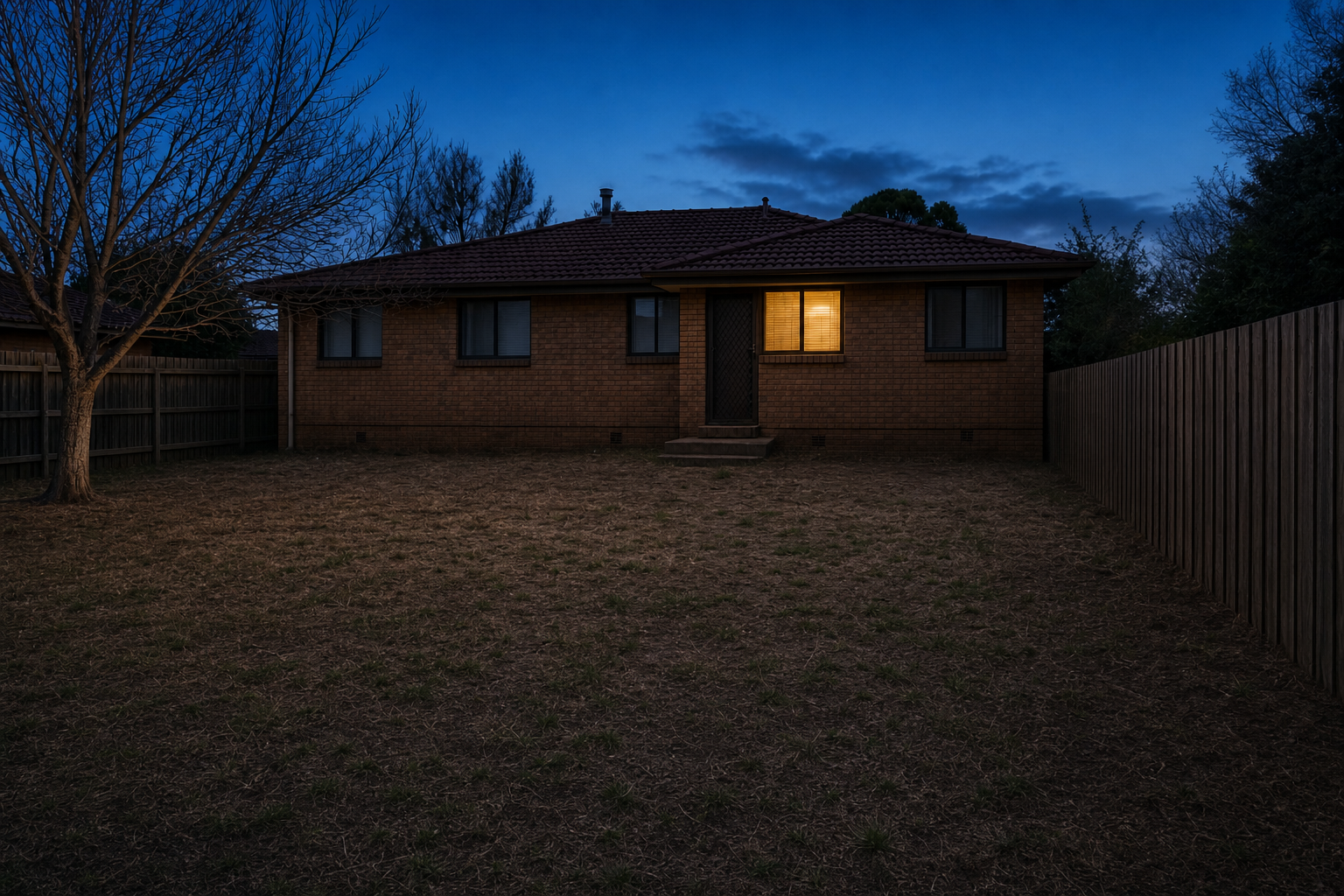 A tired Canberra backyard at dusk with dead patchy lawn, before landscaping